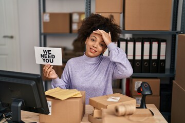 Young african american woman working at small business ecommerce holding banner stressed and frustrated with hand on head, surprised and angry face