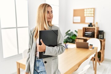 Blonde business woman at the office looking to side, relax profile pose with natural face and...