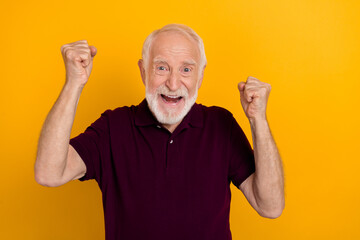 Fototapeta Photo of hooray aged man fist yell wear dark t-shirt isolated on yellow color background obraz