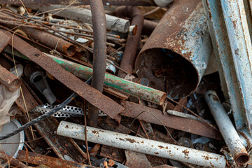 scrap metal, old rusty metal lying on green grass. Pipes, batteries, heating system is old outside
