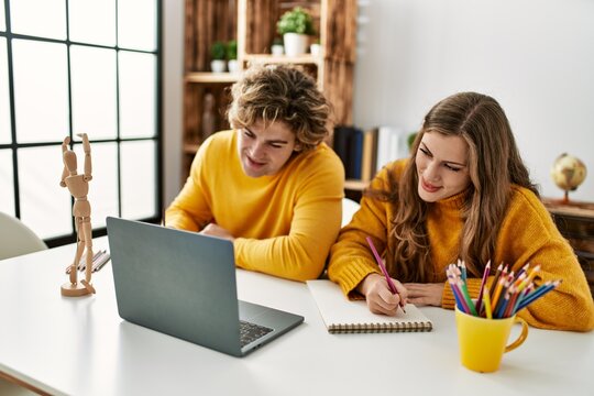 Young caucasian couple smiling confident having online art class at home