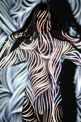 Projection from beamer or projector on woman looks like body painting with zebra stripes