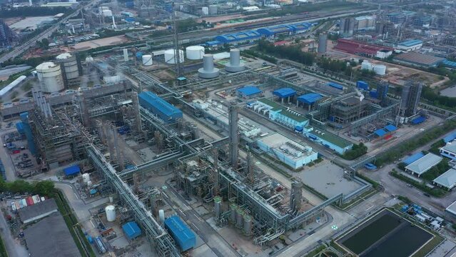 Aerial view of petrochemical oil refinery and sea in industrial engineering concept in Bangna district at night, Bangkok City, Thailand. Oil and gas tanks pipelines in industry. Modern metal factory.
