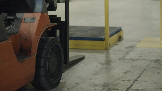 Forklift parked in front of industrial scale, waiting to do warehouse work. Cinematic details.