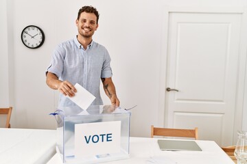 Young hispanic man smiling confident voting at electoral college