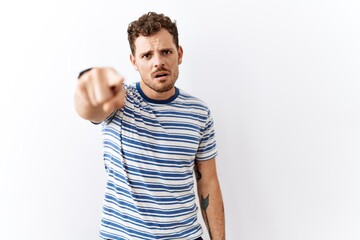 Handsome young man standing over isolated background pointing displeased and frustrated to the camera, angry and furious with you