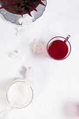 Una taza transparente de té de bayas y leche sobre una mesa blanca. Vista superior