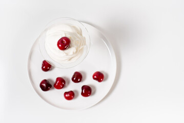 Helado de crema con cerezas sobre una mesa blanca. Postre de verano vista superior