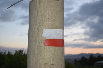 Red and white flag drawn on a light pole, which means you are on a path