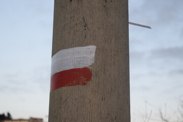Red and white flag drawn on a light pole, which means you are on a path