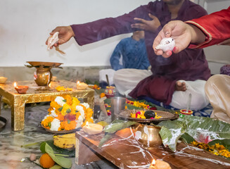 devotee doing religious ritual of holy god with conch shell and blurred background at evening