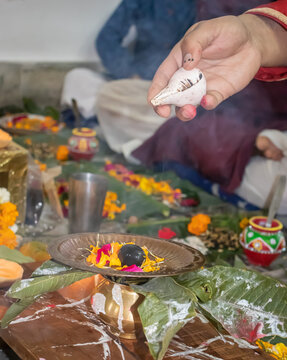 devotee doing religious ritual of holy god with conch shell and blurred background at evening
