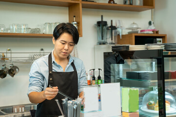 Barista in an apron making coffee in a coffee shop,Barista Cafe Coffee Grinder Pour Professional Concept.