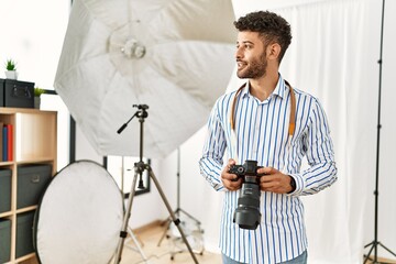 Young arab photographer man smiling happy using reflex camera at photo studio.