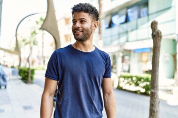 Young arab man smiling confident on a sunny day at the street