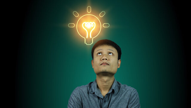 Asian men are thinking and coming up with new ideas and looking at the light bulbs lighting up above means finding solutions to problems and finding solutions. bright idea or creativity concept.