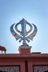 Fototapeta na wymiar khanda sikh holy religious symbol at gurudwara entrance with bright blue sky