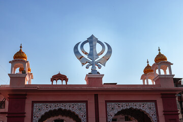 khanda sikh holy religious symbol at gurudwara entrance with bright blue sky