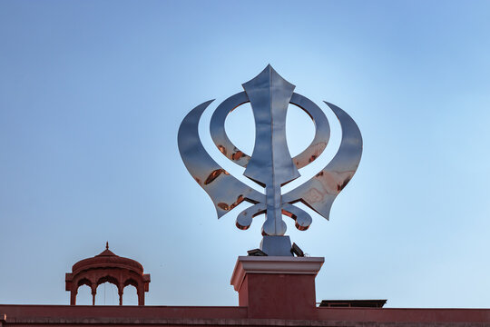 khanda sikh holy religious symbol at gurudwara entrance with bright blue sky