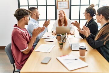 Group of business workers smiling and clapping to partner at the office.