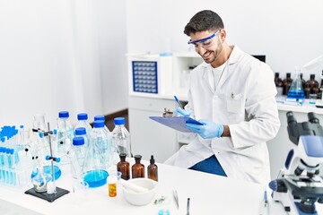 Fototapeta premium Handsome hispanic man working as scientific at laboratory