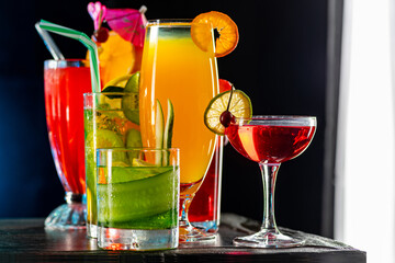 Set of coctails on bar counter in a restaurant, pub. Collection of fresh juice alcoholic drinks. Cooler beverage at nightclub on dark background