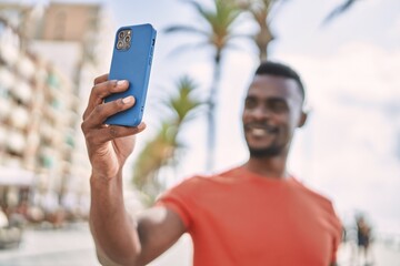 Young african american man smiling confident make selfie by the smartphone at street