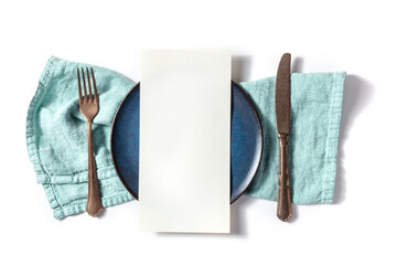 Dinner menu or invitation concept. A piece of paper on a set table, with a fork, a knife, and a blue plate, overhead flat lay shot on a white background