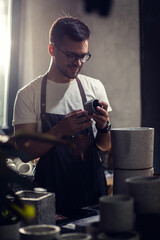 Portrait of craftsman working in his workshop making decorative concrete vase.