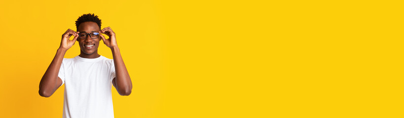 Naklejka premium Long shot with handsome black guy in stylish eyeglasses over yellow background