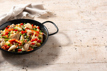 Chicken stir fry and vegetables on wooden table	