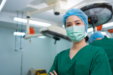 Portrait of Asian surgeon and nurse with medical mask standing with arms crossed in operation...