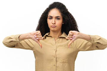 Upset young african-american woman showing rejection and negative with thumbs down gesture isolated...