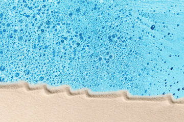 Blue water and white beach sand concept, flat lay. Background for tropical travel or skincare cosmetics.
