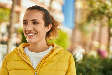 Young hispanic girl smiling happy standing at the city.
