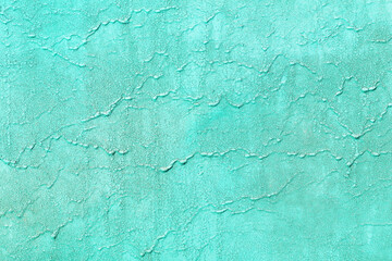 Old aquamarine painted background with cracks and scratches, flat lay. Wall with aged paint texture.