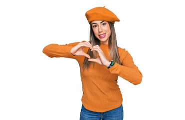 Young hispanic woman wearing french look with beret smiling in love showing heart symbol and shape with hands. romantic concept.