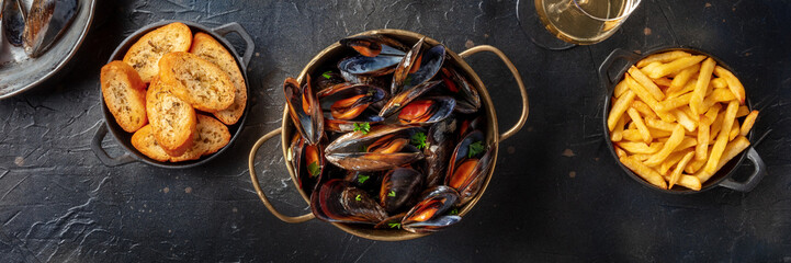 Mussels panorama. Seafood meal with shellfish, French fries and toasted bread, overhead flat lay...