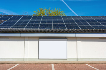 blank billboard and solar panels on a roof of a building generating sustainable energy