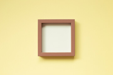 Pink picture frame on yellow background. top view, copy space