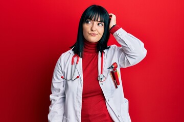 Young hispanic woman wearing doctor uniform and stethoscope confuse and wondering about question....