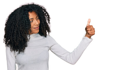 Young african american girl wearing casual clothes looking proud, smiling doing thumbs up gesture to the side