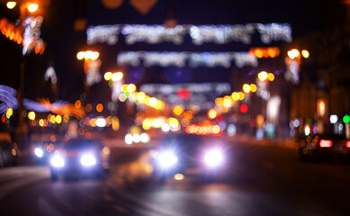 Fototapeta na wymiar Defocused image, night city street. Blurred lights and houses.