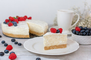 Classic sliced cheesecake with fresh berries - raspberries and  blueberries, close up. No baked, Tasty cake with cheese  