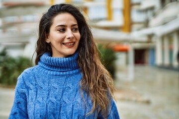 Young hispanic woman smiling happy standing at the city.