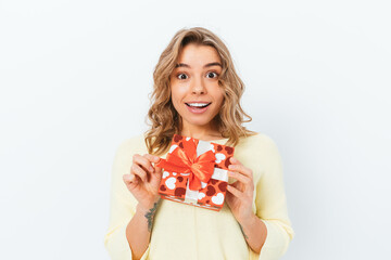 Joyful young woman holding ribbon on her gift box
