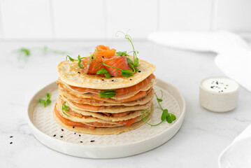stack of oatmeal pancakes with salted salmon and herbs - obrazy, fototapety, plakaty