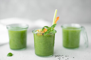 chilled cucumber gazpacho with celery, tomato and basil in a glass