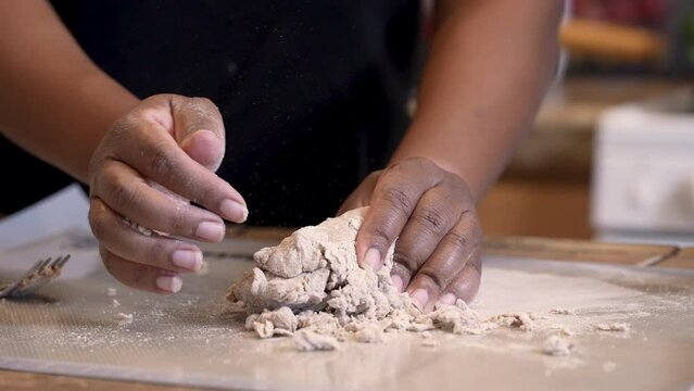 Black hands seen kneading unleavened matzah Passover bread - isolated slow motion
