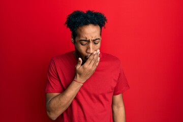 Fototapeta na wymiar Young african american man with beard wearing casual red t shirt bored yawning tired covering mouth with hand. restless and sleepiness.